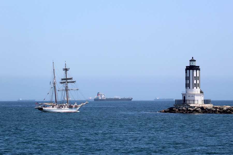 Sailboat exiting through Angel's Gate in the Harbor with the LA lighthouse
